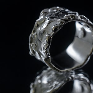Molten Metal Chunky Ring, Dramatic Jewellery for Men and Women, Unisex Broad Ring with Irregular Edges. On Black Background with Mirror Reflection from Underneath.