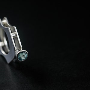 Contemporary ring with reticulated sterling silver and keum boo 24k gold foil and blue topaz stone, double-sided. On Black Background.