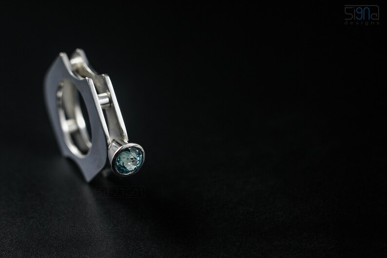 Contemporary ring with reticulated sterling silver and keum boo 24k gold foil and blue topaz stone, double-sided. On Black Background.
