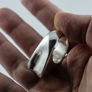 Geometric Ring, Contemporary Design, Massive, Bold and Unisex, with High Shine Finish. In hand with white background.