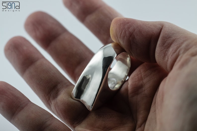 Geometric Ring, Contemporary Design, Massive, Bold and Unisex, with High Shine Finish. In hand with white background.