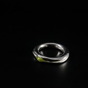 Bold Irregular Unisex Ring in Sterling Silver with Green Natural Peridot Nugget, Thick Forged Chunky Jewelry, Hammered Unique Ring. On Black Background.