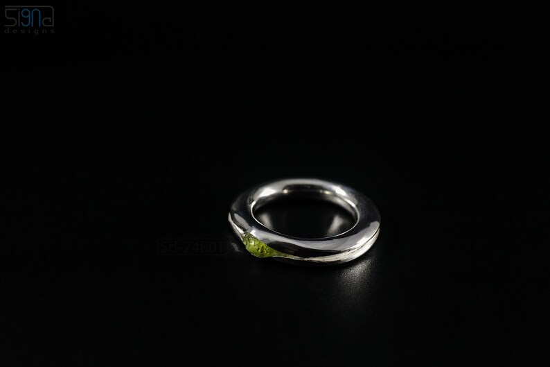 Bold Irregular Unisex Ring in Sterling Silver with Green Natural Peridot Nugget, Thick Forged Chunky Jewelry, Hammered Unique Ring. On Black Background.