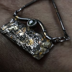 Mixed Metal Organic Necklace with Greenish Blue Sapphire and Topaz, Dark Texture, Statement Edgy Asymmetrical Chain, Silver and Gold Accents. On Hand Skin.