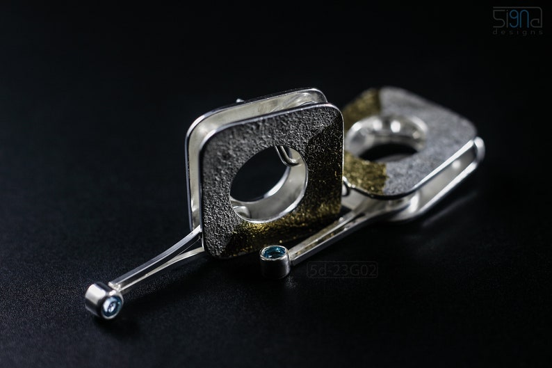 Contemporary dangle earrings with reticulated sterling silver, keum boo 24k gold foil and blue topaz, double-sided. On Black Background.