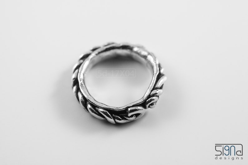 Primitive, raw, organic unisex sterling silver ring with twisted design and patina. On white background. Top view.