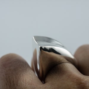Geometric Ring, Contemporary Design, Massive, Bold and Unisex, with High Shine Finish. On finger, white background.