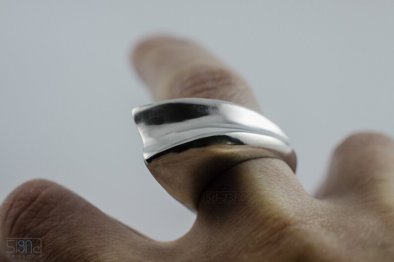 Geometric Ring, Contemporary Design, Massive, Bold and Unisex, with High Shine Finish. On finger, with white background.