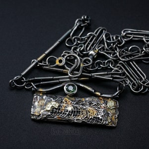 Mixed Metal Organic Necklace with Greenish Blue Sapphire and Topaz, Dark Texture, Statement Edgy Asymmetrical Chain, Silver and Gold Accents. On Black Background.