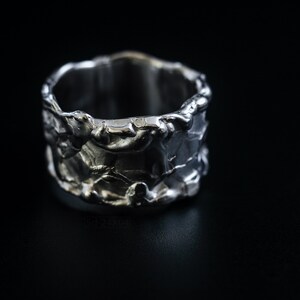 Molten Metal Chunky Ring, Dramatic Jewellery for Men and Women, Unisex Broad Ring with Irregular Edges. On Black Background.