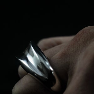 Geometric Ring, Contemporary Design, Massive, Bold and Unisex, with High Shine Finish. On finger, black background.