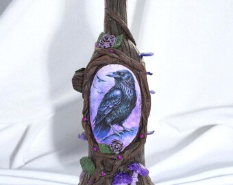 May include: A decorative bottle with a raven illustration. The bottle is brown, with a tree bark texture, and adorned with purple roses, mushrooms, and berries. The raven is depicted in a purple and blue oval frame.