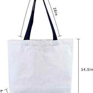 May include: White canvas tote bag with navy blue handles. The bag measures 20.5 inches wide, 14.5 inches tall, and has a handle drop of 28 inches.