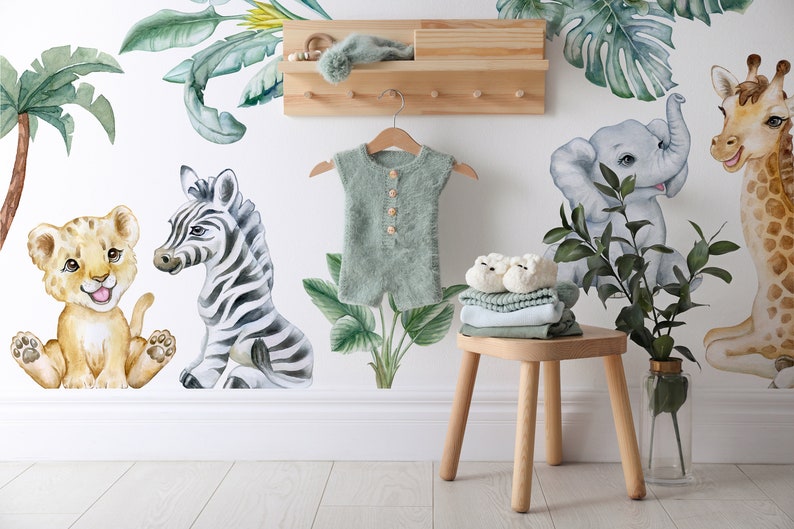 May include: A nursery wall decal set featuring a zebra, lion, giraffe, elephant, and palm trees. The decals are in a watercolour style and are perfect for a jungle-themed nursery.