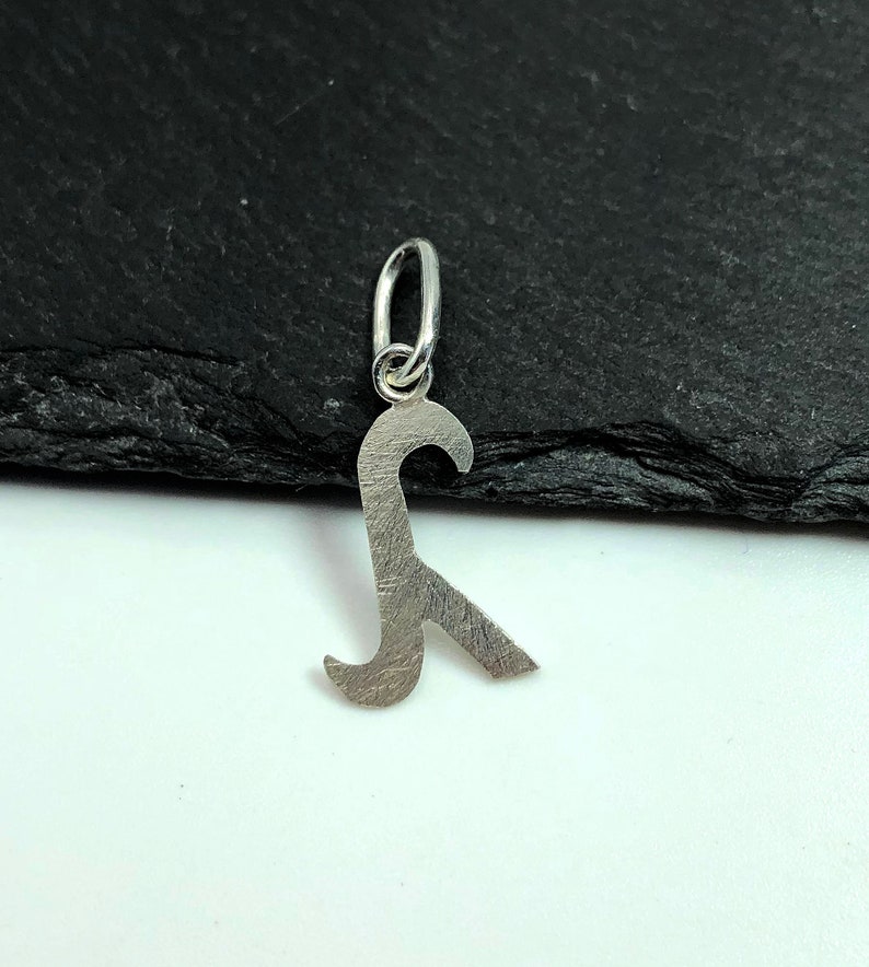 K&ouml;nnte beinhalten: Silberner Anh&auml;nger in Form eines Flaschen&ouml;ffners. Der Anh&auml;nger hat oben eine Schlaufe zum Anbringen an einer Halskette oder einem Armband.