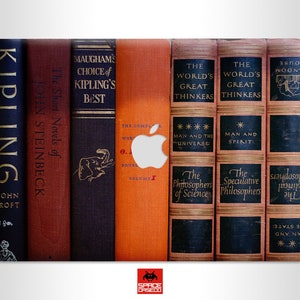 Puede incluir: Una piel para portátil con un diseño de lomos de libros. Los lomos son de diferentes colores y tienen títulos como "Kipling's Best", "The World's Great Thinkers" y "The Short Novels of John Steinbeck".