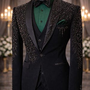 Peut inclure: Un costume noir formel avec des ornements de perles complexes sur les revers et les manches. Le costume comprend un gilet assorti, une chemise verte et un n&oelig;ud papillon. Une pochette verte ajoute une touche de couleur.