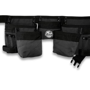 May include: A black tool belt with multiple pockets and a black belt with a buckle. The belt has the text "Built for the Trades" and the logo "Graintex" on it.