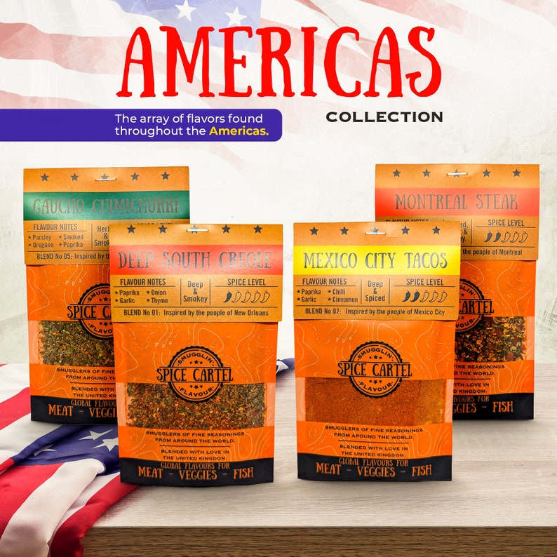 May include: Four orange and white spice packets with the text "Spice Cartel" and "Americas Collection" on the front. Each packet features a different flavor profile: Gaucho Chimichurri, Deep South Creole, Mexico City Tacos, and Montreal Steak. The packets are arranged on a wooden surface with an American flag in the background.