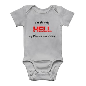 Op de afbeelding: Een grijze baby romper met de tekst "I'm the only HELL my Momma ever raised!" in zwart en rood. Het woord "HELL" is in rood met vlammen.