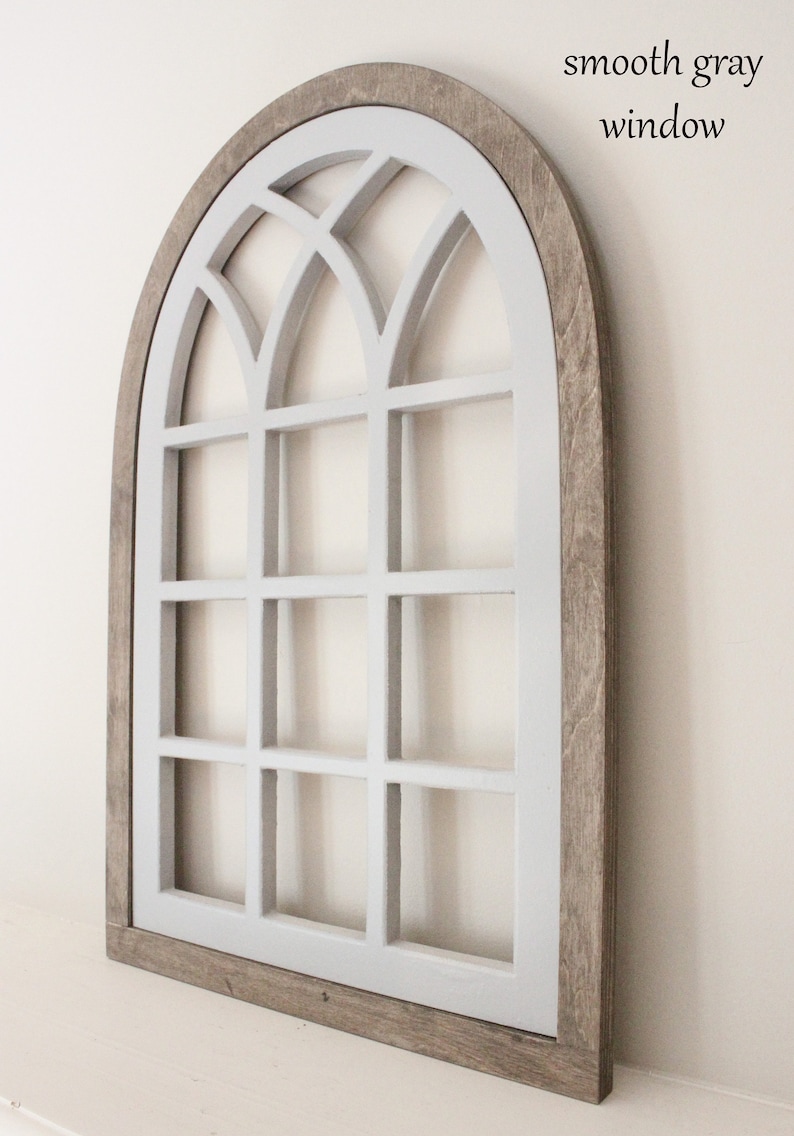 Pu&ograve; includere: Una finestra ad arco con cornice in legno grigio con un motivo a griglia dipinto di bianco. La finestra &egrave; un'appendice decorativa per la parete.