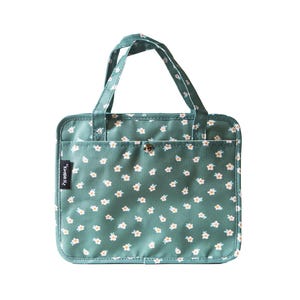 May include: A teal tote bag with a white floral pattern. The bag has two handles and a front pocket. A small tag with text is on the front. The bag is rectangular with rounded corners.