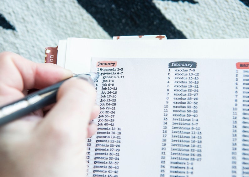 May include: A close-up of a calendar with the months January, February, and March listed. The days of the month are numbered and each day has a corresponding Bible verse listed next to it.