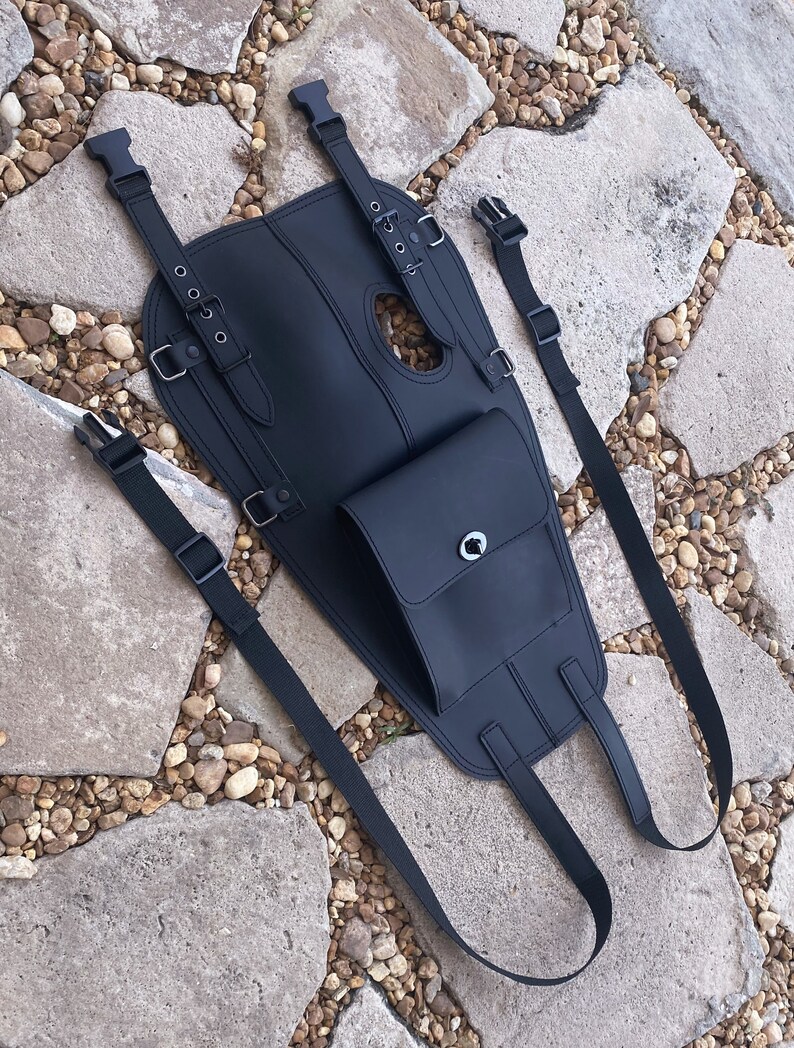 Puede incluir: Bolsa de dep&oacute;sito de moto de cuero negro con correas ajustables y un peque&ntilde;o bolsillo con cremallera.