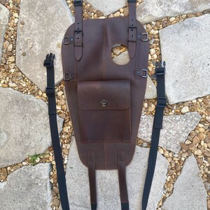 Puede incluir: Una bolsa de dep&oacute;sito de motocicleta de cuero marr&oacute;n con dos correas ajustables y un peque&ntilde;o bolsillo frontal. La bolsa tiene un cierre de hebilla y un agujero en la parte superior para una tapa de gasolina.