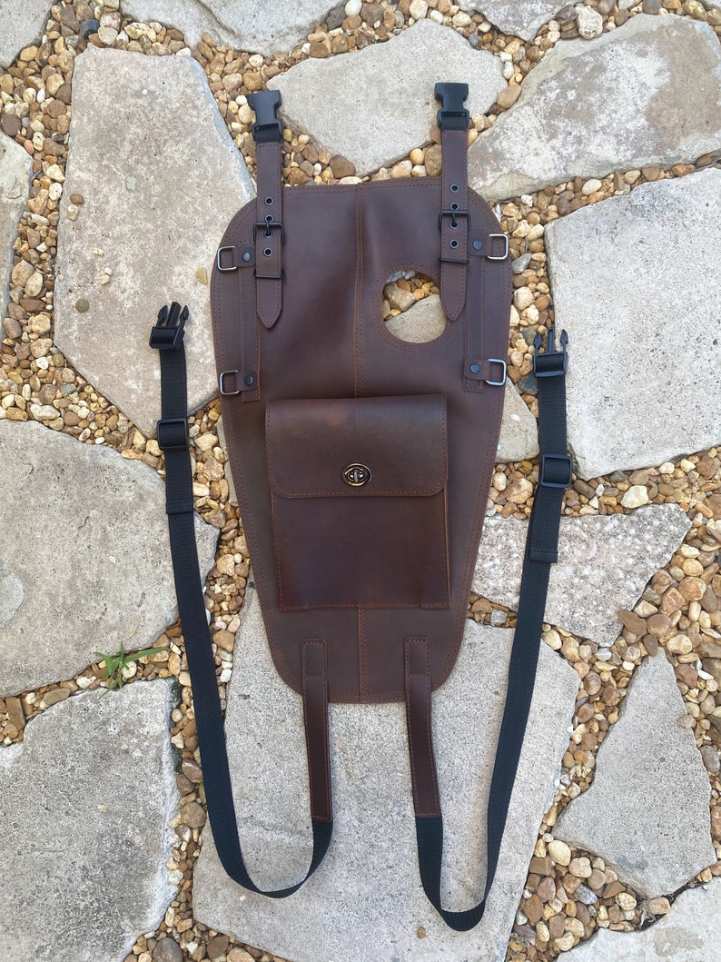 Puede incluir: Una bolsa de dep&oacute;sito de motocicleta de cuero marr&oacute;n con dos correas ajustables y un peque&ntilde;o bolsillo frontal. La bolsa tiene un cierre de hebilla y un agujero en la parte superior para una tapa de gasolina.