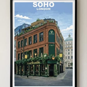 Op de afbeelding: Een ingelijste print met een illustratie van The Devonshire pub in Soho, Londen. De afbeelding toont het gebouw in bruine en groene tinten, met de tekst "SOHO LONDON" bovenaan. De lucht is blauw met witte wolken.