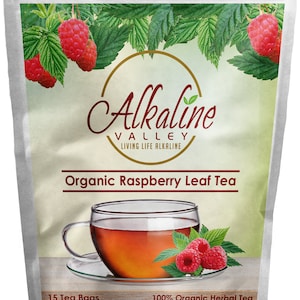 May include: A white resealable pouch with a green and white background. The pouch contains 15 tea bags of organic raspberry leaf tea. The text "Alkaline Valley Living Life Alkaline" is printed in gold on the pouch. The text "Organic Raspberry Leaf Tea" is printed in brown on the pouch. The text "100% Organic Herbal Tea" is printed in brown on the pouch. The text "Alkalinevalley.com" is printed in brown on the pouch.