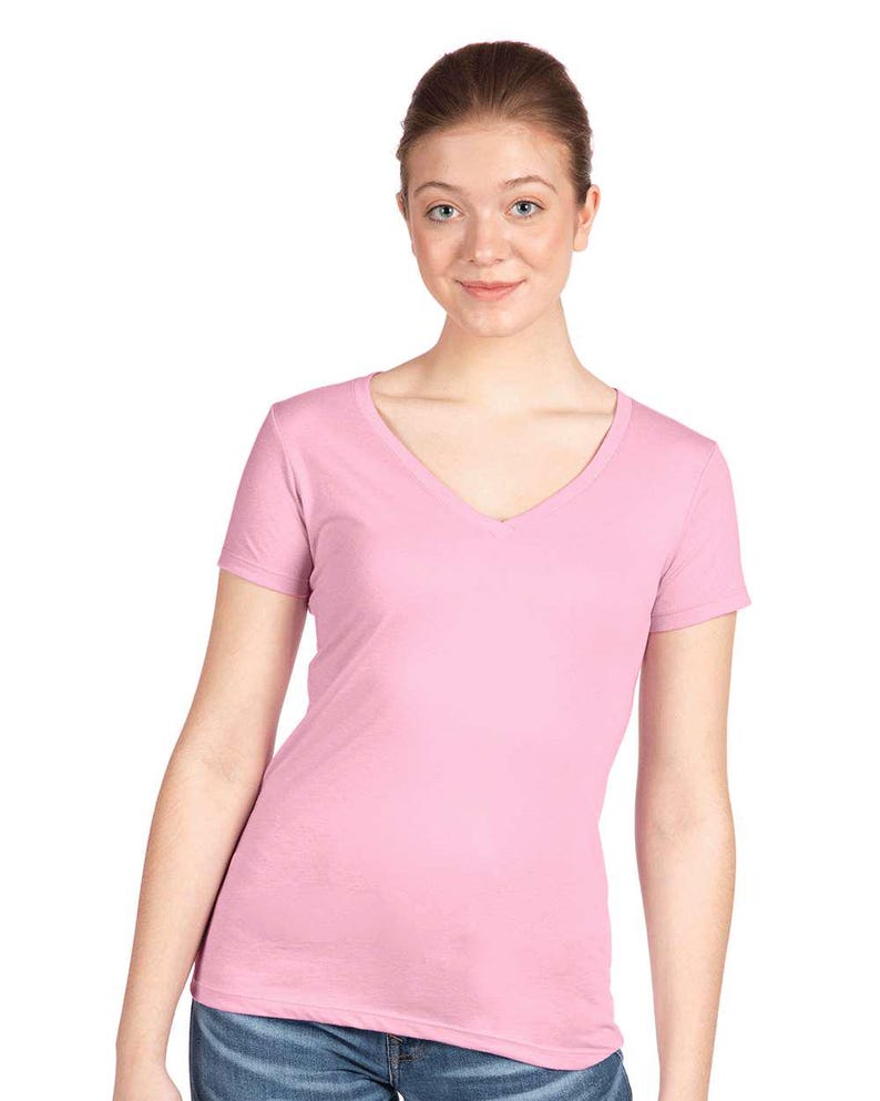 May include: A light pink short-sleeved t-shirt with a V-neckline. The garment is made of a solid-colored fabric and features a standard fit with short sleeves and a clean hemline at the waist, providing a simple and functional design for daily wear.