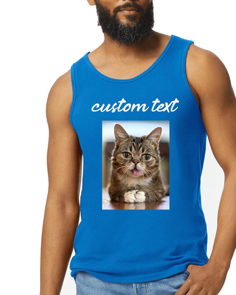 Peut inclure: Un d&eacute;bardeur bleu vif sans manches avec une impression graphique rectangulaire repr&eacute;sentant un chat tigr&eacute; brun tirant la langue. Au-dessus de l'image du chat, les mots custom text sont imprim&eacute;s dans une police cursive blanche en minuscules.