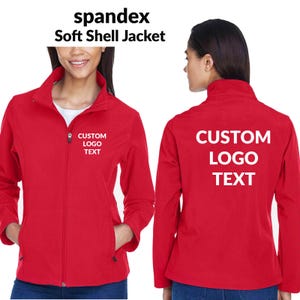 May include: Red soft shell jacket with a full zipper, pockets, and a stand-up collar. The front of the jacket has the text "CUSTOM LOGO TEXT" and the back has the same text. The jacket is made of spandex.