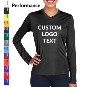 May include: Black long-sleeve V-neck shirt with the text "CUSTOM LOGO TEXT" in white. The word "Performance" is above the shirt. A color chart is on the left side of the image.