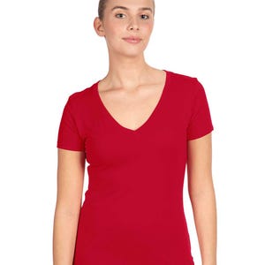 May include: A solid red short-sleeved t-shirt featuring a deep V-neckline. The garment is constructed from a smooth, opaque fabric and has a fitted silhouette that extends to the hip area, providing a clean and simple look for everyday wear.