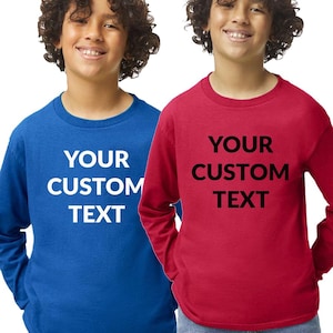 May include: Two children wearing long-sleeved shirts. One shirt is royal blue, the other is red. Both shirts have the text "YOUR CUSTOM TEXT" in white and black, respectively. The shirts are made of a soft material and are suitable for casual wear.