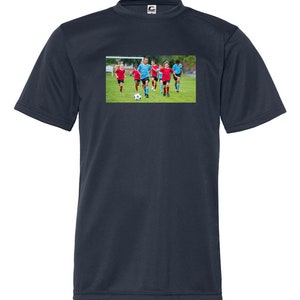 May include: A dark blue t-shirt with a graphic of a group of children playing soccer on a green field. The children are wearing blue and red soccer uniforms.