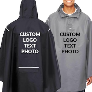 May include: Two rain ponchos, one black and one gray, with hoods and front pockets. The text "CUSTOM LOGO TEXT PHOTO" is printed in white on the back of the black poncho and on the front of the gray poncho.