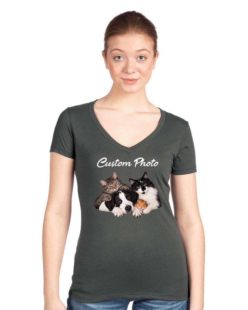 May include: A dark charcoal gray V-neck t-shirt featuring a graphic print of a tabby cat, a black and white dog, and a small hamster huddled together. Above the animal group, the text Custom Photo is printed in a white, cursive script font.