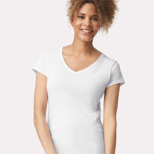 Op de afbeelding: Een effen wit T-shirt met korte mouwen en een V-hals. Het kledingstuk is gemaakt van een effen witte stof en heeft een standaard pasvorm met korte mouwen en een nette afwerking aan de zoom van de taille en de mouwen.