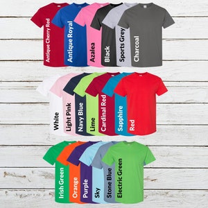 May include: A collection of short-sleeved t-shirts in various colors, including red, blue, pink, black, and gray. Each shirt is displayed with its color name, such as "Antique Cherry Red" and "Azalea". The shirts are arranged in rows.