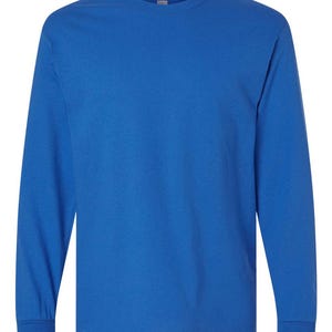 May include: A solid royal blue long-sleeve t-shirt featuring a classic crew neckline and straight-cut sleeves with ribbed cuffs. The garment is constructed from a plain, opaque fabric in a vibrant, uniform blue color throughout the entire piece.