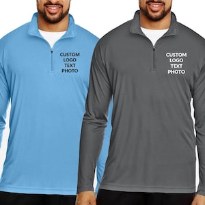 May include: Two long-sleeved athletic shirts, one light blue and one gray, with a quarter-zip collar. Each shirt has the text "CUSTOM LOGO TEXT PHOTO" printed on the chest. The shirts are made of a lightweight, breathable material.