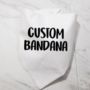May include: White cotton bandana with black text that reads "CUSTOM BANDANA".