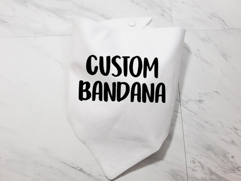 May include: White cotton bandana with black text that reads "CUSTOM BANDANA".