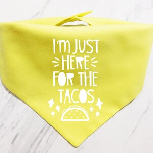 Op de afbeelding: Gele bandana met de tekst "I'm just here for the tacos" in wit met een witte taco-afbeelding.