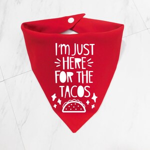 Op de afbeelding: Rode bandana met witte tekst die zegt "Ik ben hier alleen voor de taco's" en een witte omtrek van een taco.