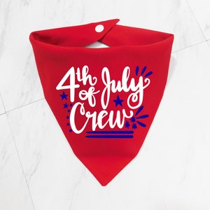 May include: Red bandana with a white design that says "4th of July Crew" with blue stars and fireworks.
